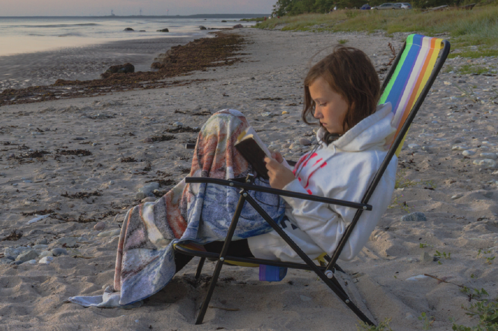 girl reading at beach